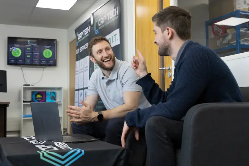 Two CAP Technologies engineers talking with a client over a laptop