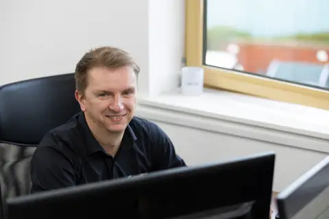 CAP engineer smiling at their workstation
